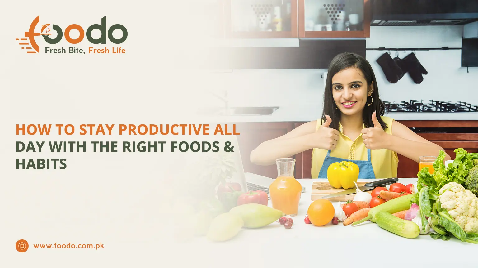 Smiling young woman in kitchen apron giving thumbs up, surrounded by fresh vegetables, fruits, orange juice, and healthy ingredients on counter with laptop, boosting productivity and healthy habits at work